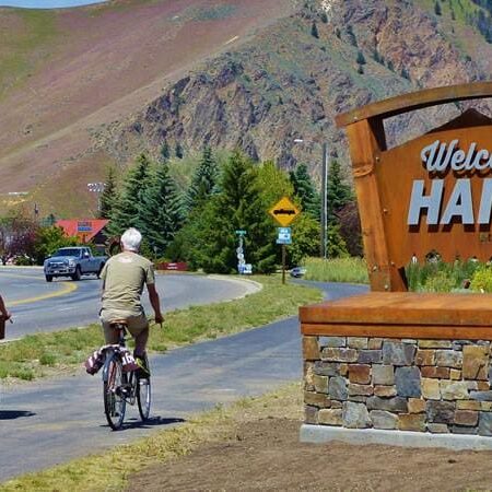 Two People Cycling By Welcome Board