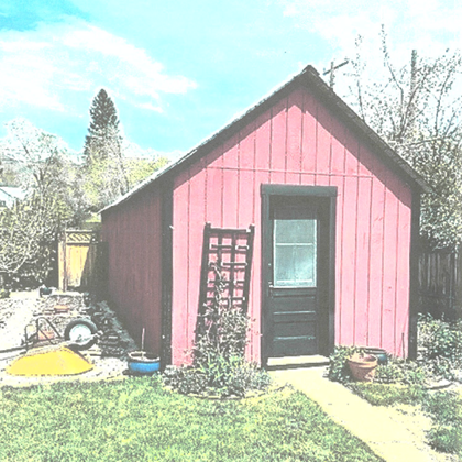 Front view of a hut shaped house with a small garden