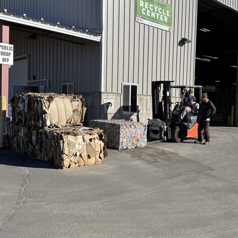 Recycling center with stacked paper bales and forklift